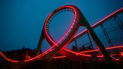 a roller coaster lit up at night with red lights
